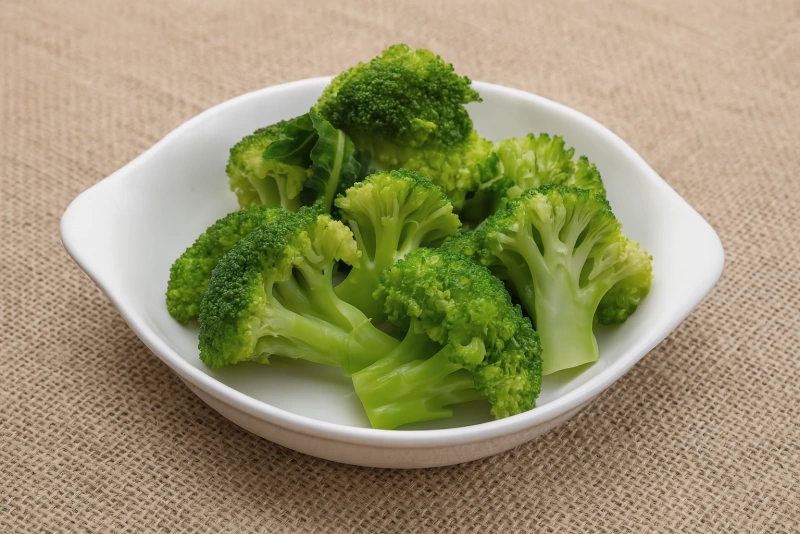 brócoli cocido verde y nutritivo en un plato blanco sobre una mesa