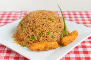 Plato colorido de arroz chaufa de pescado con verduras frescas