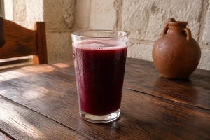 Vaso de chicha oscura con espuma sobre mesa de una picantería arequipeña