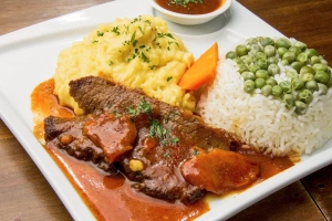 plato de asado de carne con arroz y puré de papas