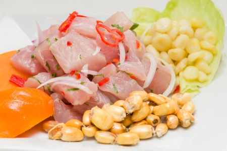 Plato de ceviche peruano servido con cancha, choclo y camote