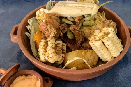 Plato de pachamanca con carnes variadas y choclo