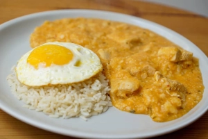 plato de pepián de choclo con arroz y huevo frito