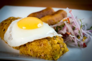 tacu tacu con huevo frito, plátano y salsa criolla
