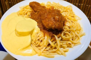plato de tallarines rojos con pollo y huancaína